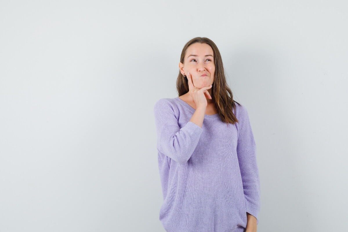 Young woman touching jaw in discomfort from wisdom teeth pain and swelling in Chicago